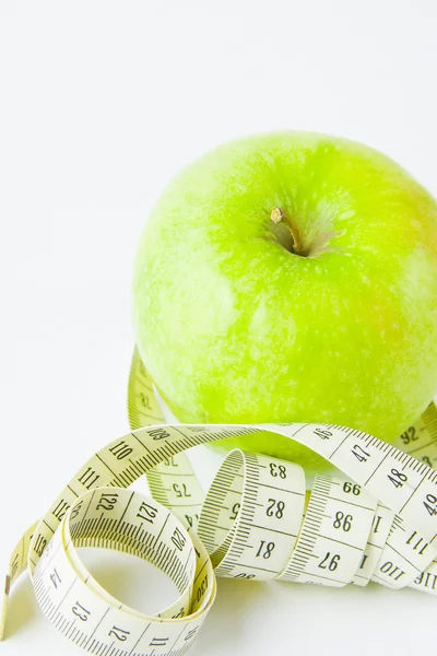 Grüner Apfel und Zentimeter auf weißem Hintergrund — Stockfoto