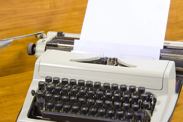 Oude schrijfmachine en schoon vel papier — Stockfoto