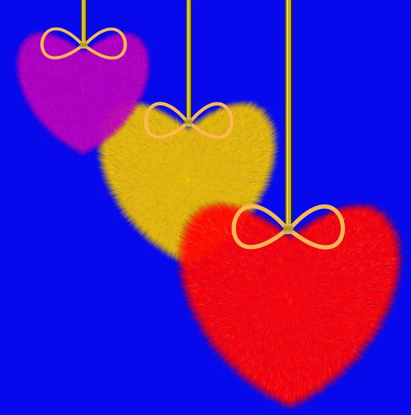 Tres corazones mullidos varicolores sobre un fondo azul —  Fotos de Stock