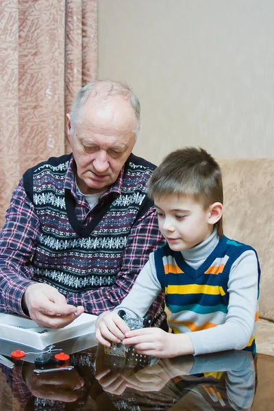 Abuelo con un nieto jugar un diseñador — Foto de Stock