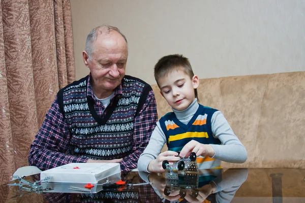 Nonno con un nipote giocare un designer — Foto Stock