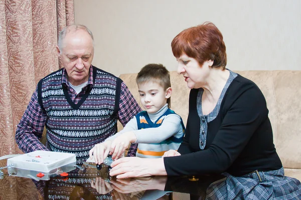 Een grootmoeder, grand-papa, spelen met een kleinkind in een ontwerper — Stockfoto