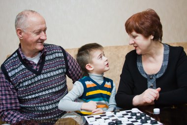 Büyükanne, grand-baba, oyun dama bir torun ile