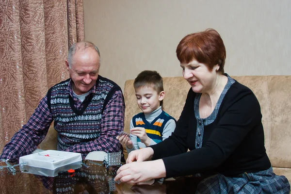 Een grootmoeder, grand-papa, spelen met een kleinkind in een ontwerper — Stockfoto