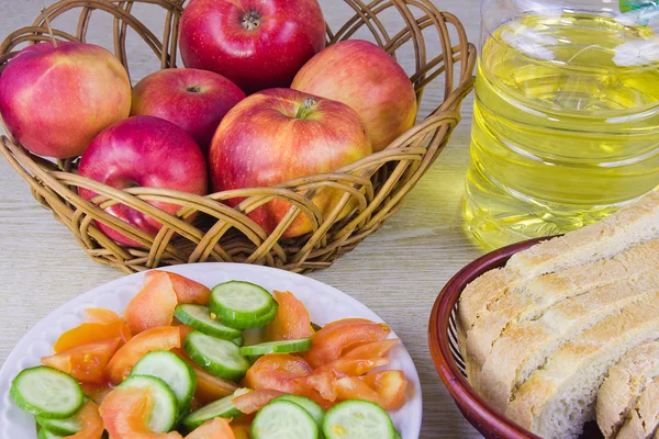 Lechuga con verduras y jarrón de paja con manzanas rojas —  Fotos de Stock