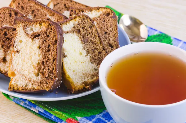 Kubek z gorącą herbatę i słodkie ciasta na dekoracyjne serwetki — Zdjęcie stockowe