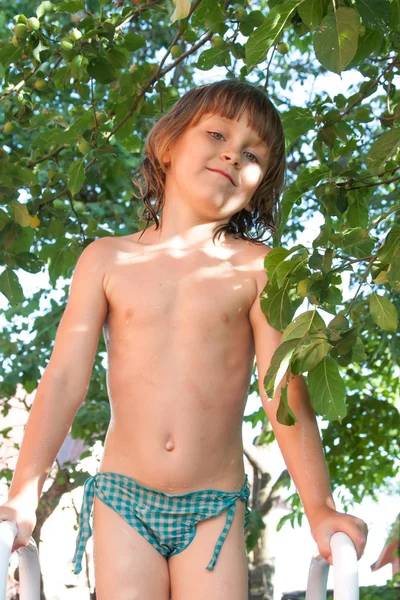 neşeli bir kız bir arka plan üzerinde bir ağacı duruyor.