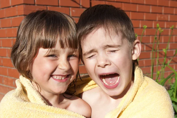 Een grappig meisje en jongen zijn gewikkeld in een handdoek — Stockfoto