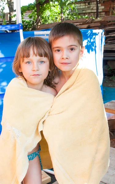 Uma menina alegre e menino são envoltos em uma toalha — Fotografia de Stock