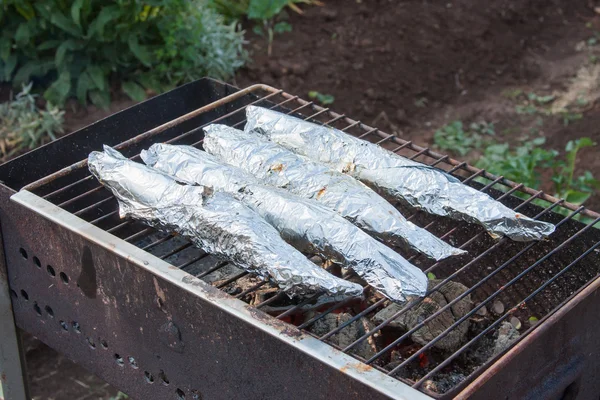 Préparation de poisson en papier d'aluminium sur un gril — Photo