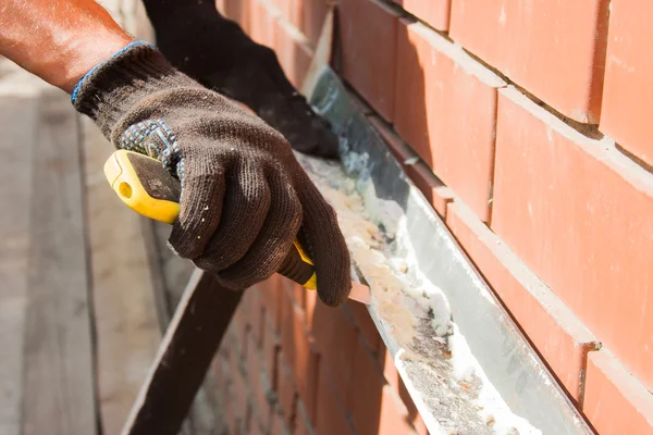 Man in a working wear cut away old material from a frisket — Stock Photo, Image