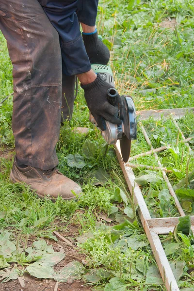 Man arbetar utanför, skär en metall — Stockfoto