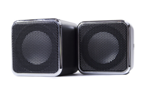Two square black speakers close-up on a white background
