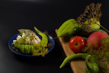 Baharatlar ve baharatlar taze biber, domates ve salatalıklar için siyah arka planda..