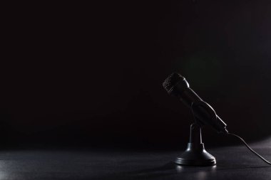 Evde karaokeye yaklaşmak, siyah arka planda siyah mikrofon kullanmak..