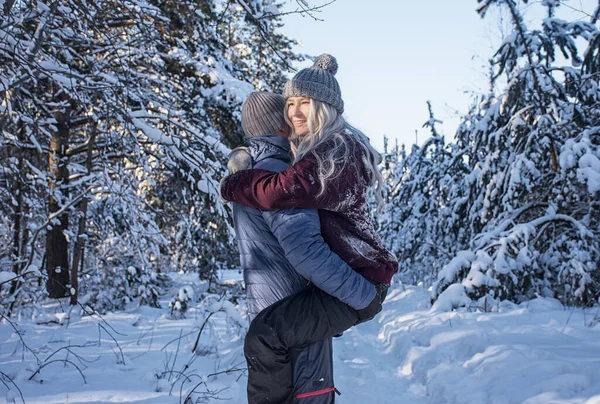 Glückliches Paar Umarmt Sich Bei Einem Spaziergang Verschneiten Wald lizenzfreie Stockfotos