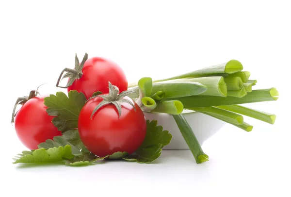 Lente-uitjes en cherry tomaat in kom — Stockfoto