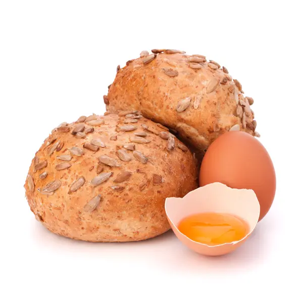 Bun with seeds and broken egg — Stock Photo, Image