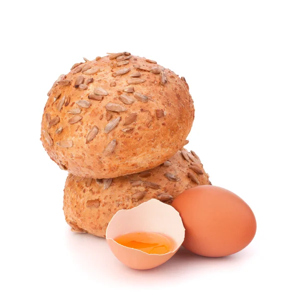 Bun with seeds and broken egg — Stock Photo, Image