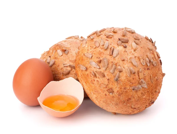 Bun with seeds and broken egg — Stock Photo, Image