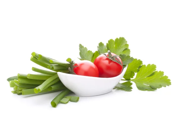 Lente-uitjes en cherry tomaat in kom — Stockfoto