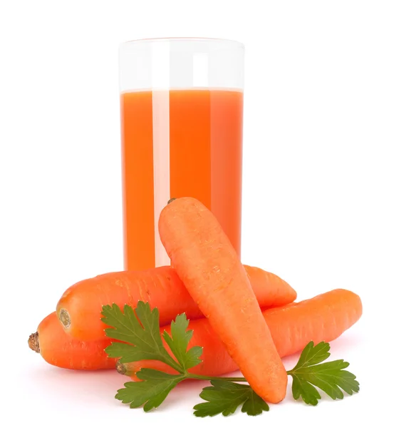 Morot juice glas och morot knölar — Stockfoto