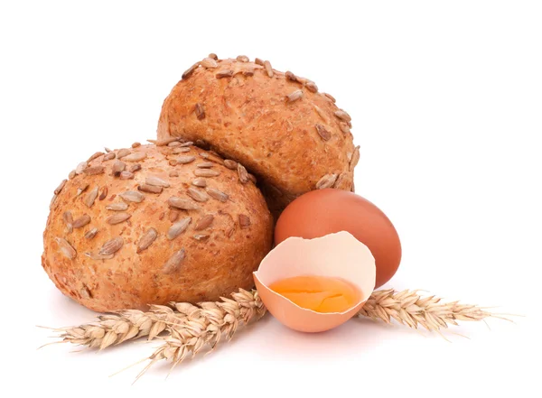 Bun with seeds and broken egg — Stock Photo, Image