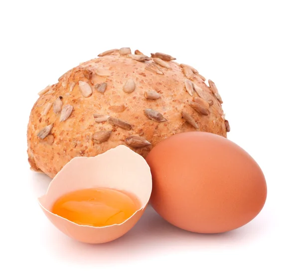 Bun with seeds and broken egg — Stock Photo, Image