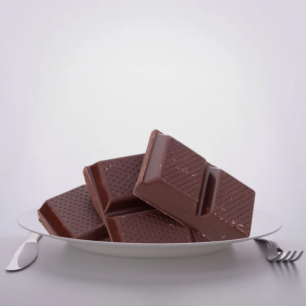 Chocolate bars stack on plate. — Stock Photo, Image