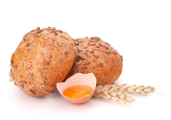 Bun with seeds and broken egg — Stock Photo, Image