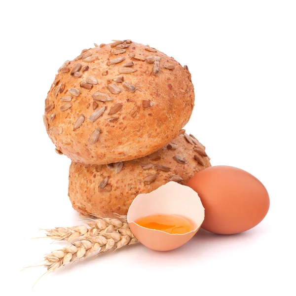 Bun with seeds and broken egg — Stock Photo, Image