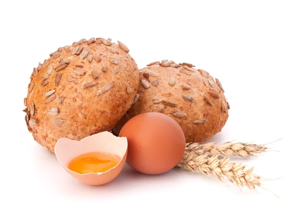 Bun with seeds and broken egg — Stock Photo, Image