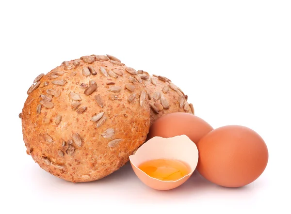 Bun with seeds and broken egg — Stock Photo, Image