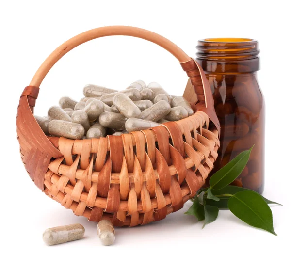 Herbal drug capsules in wicker basket. Alternative medicine conc — Stock Photo, Image