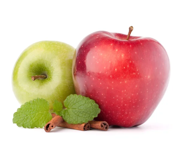 Red and green apples, cinnamon sticks and mint leaves still life — Stock Photo, Image