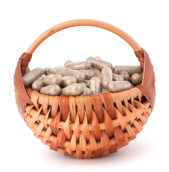 Herbal drug capsules in wicker basket. Alternative medicine conc — Stock Photo, Image