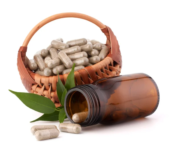 Herbal drug capsules in wicker basket. Alternative medicine conc — Stock Photo, Image