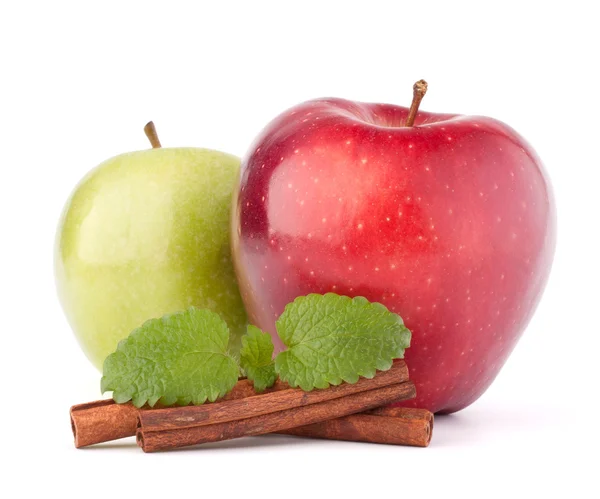 Red and green apples, cinnamon sticks and mint leaves still life — Stock Photo, Image