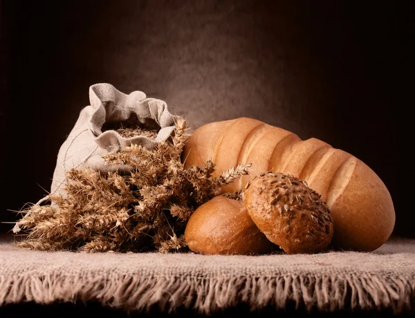 Pão, saco de farinha e orelhas bando ainda vida — Fotografia de Stock