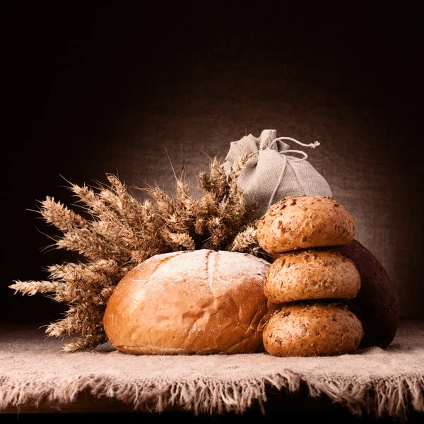 Pan, saco de harina y orejas manojo bodegón — Foto de Stock