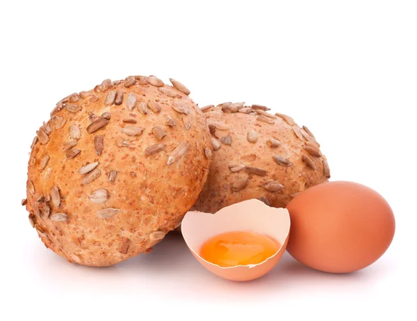 Bun with seeds and broken egg — Stock Photo, Image