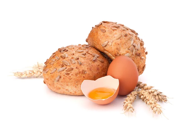 Bun with seeds and broken egg — Stock Photo, Image