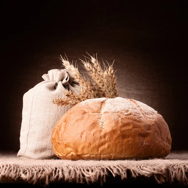 Pão, saco de farinha e orelhas bando ainda vida — Fotografia de Stock