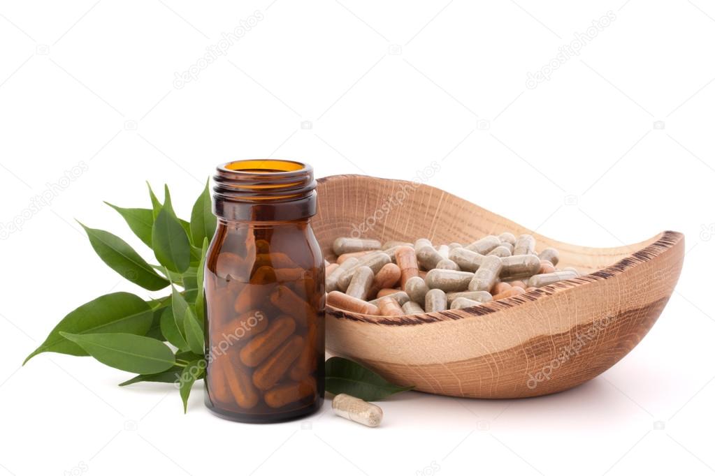 Herbal drug capsules in brown glass bottle. Alternative medicine