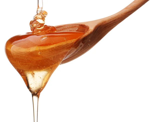 Miel dégoulinant d'une trempette au miel en bois isolée sur le dos blanc — Photo