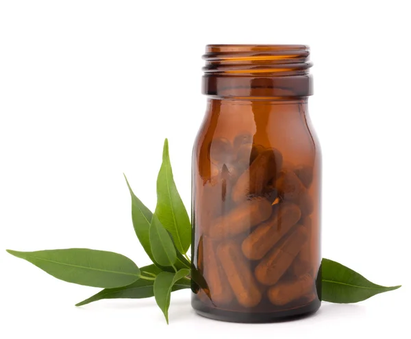 Cápsulas de hierbas medicinales en frasco de vidrio marrón. Medicina alternativa — Foto de Stock