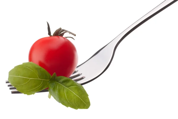 Hoja de albahaca y tomate cherry sobre tenedor aislado sobre fondo blanco —  Fotos de Stock
