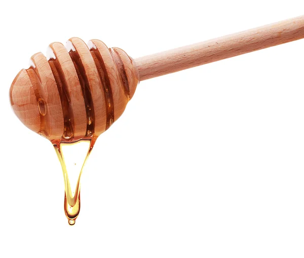 Miel dégoulinant d'une trempette au miel en bois isolée sur le dos blanc — Photo