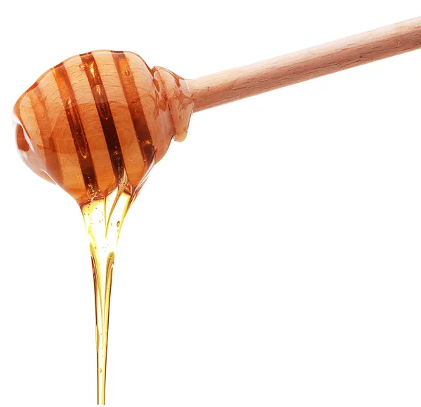 Мед капает из деревянного медового ковша, изолированного на белой спине — стоковое фото