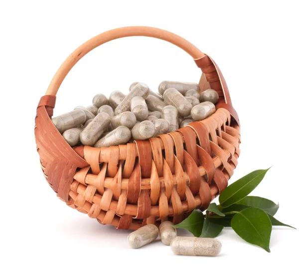 Herbal drug capsules in wicker basket. Alternative medicine — Stock Photo, Image